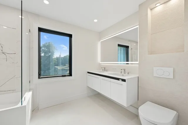 a bathroom with a sink a toilet and mirror