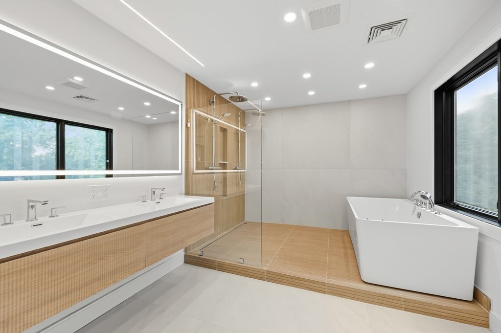 863 Main Street Reading, MA 01867 - Photo 24 of 42 a bathroom with a sink a large mirror and a bathtub