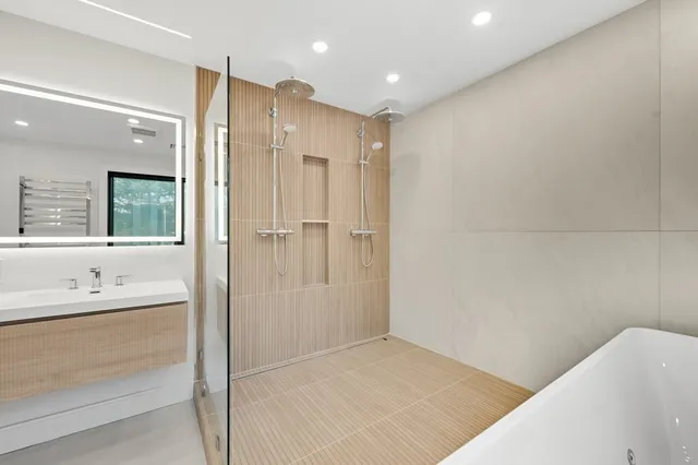 a bathroom with a double vanity sink a toilet and shower