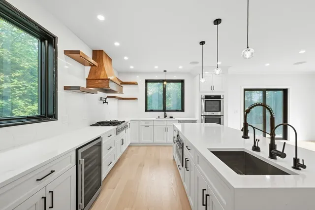 a kitchen with counter top space a sink stainless steel appliances and windows