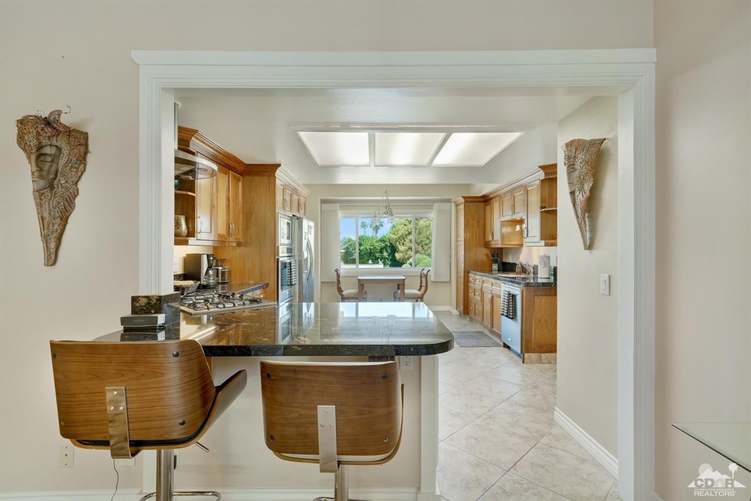 72671 Homestead Road Palm Desert, CA 92260 - Photo 16 of 39 a dining hall with stainless steel appliances granite countertop a coffee maker a sink and a refrigerator