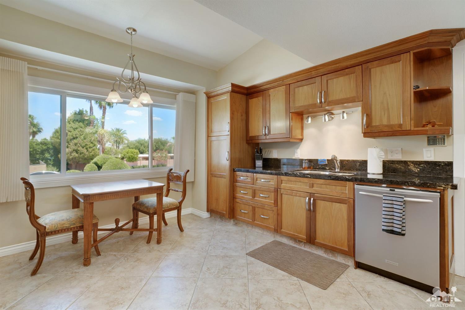 72671 Homestead Road Palm Desert, CA 92260 - Photo 19 of 39 a kitchen with a dining table chairs and refrigerator