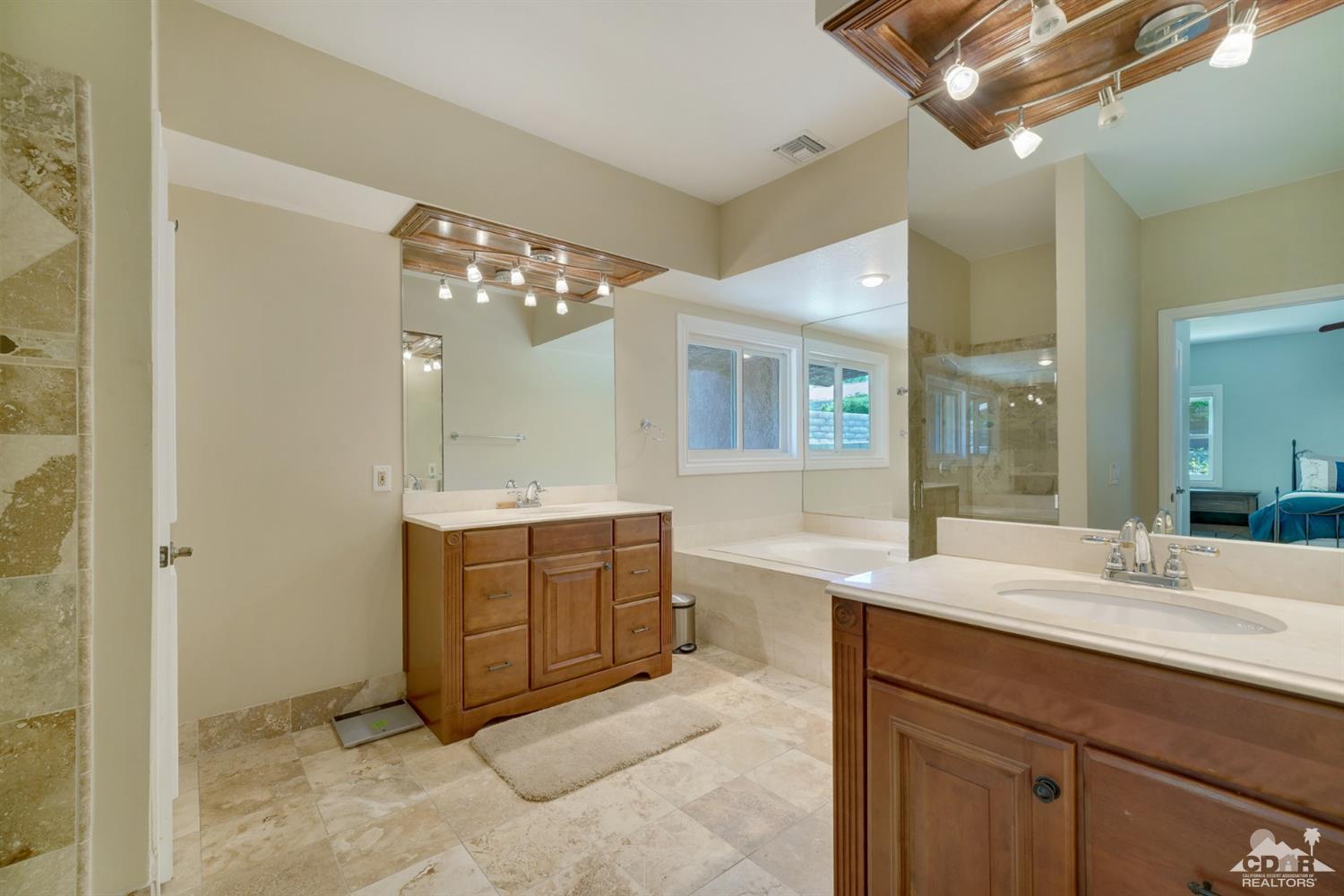 72671 Homestead Road Palm Desert, CA 92260 - Photo 23 of 39 a spacious bathroom with a granite countertop sink a mirror and a shower