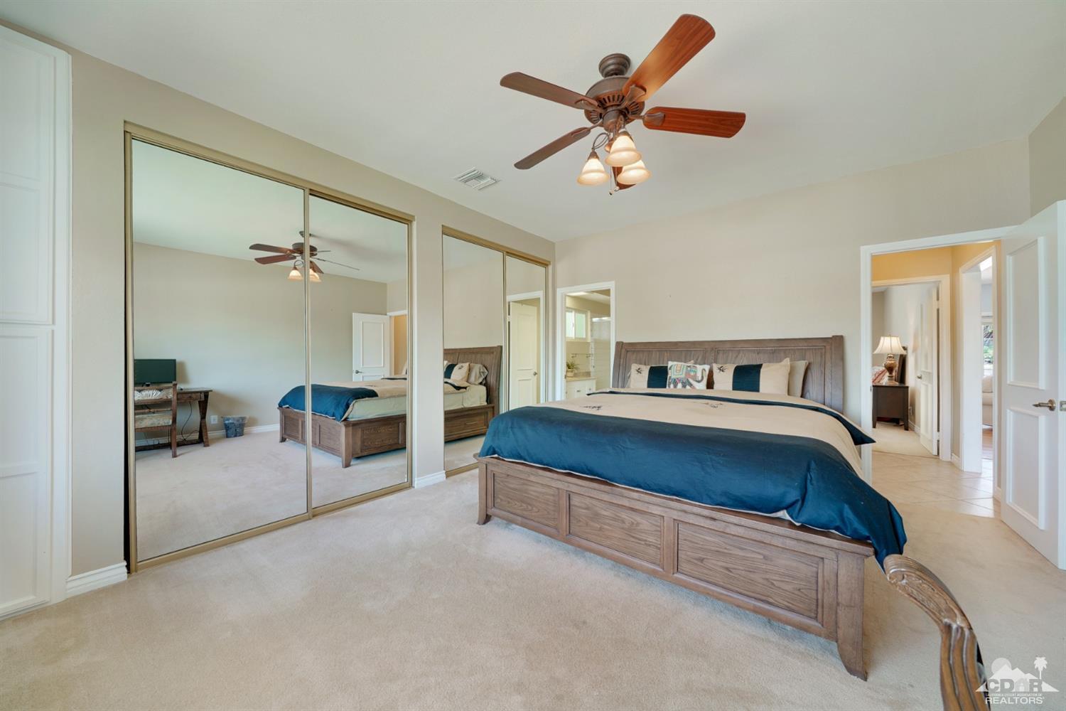 72671 Homestead Road Palm Desert, CA 92260 - Photo 25 of 39 a spacious bedroom with a bed and a chandelier