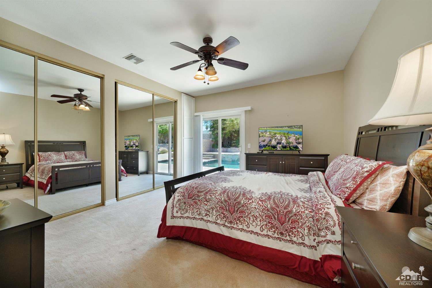 72671 Homestead Road Palm Desert, CA 92260 - Photo 27 of 39 a bedroom with a bed and a chandelier