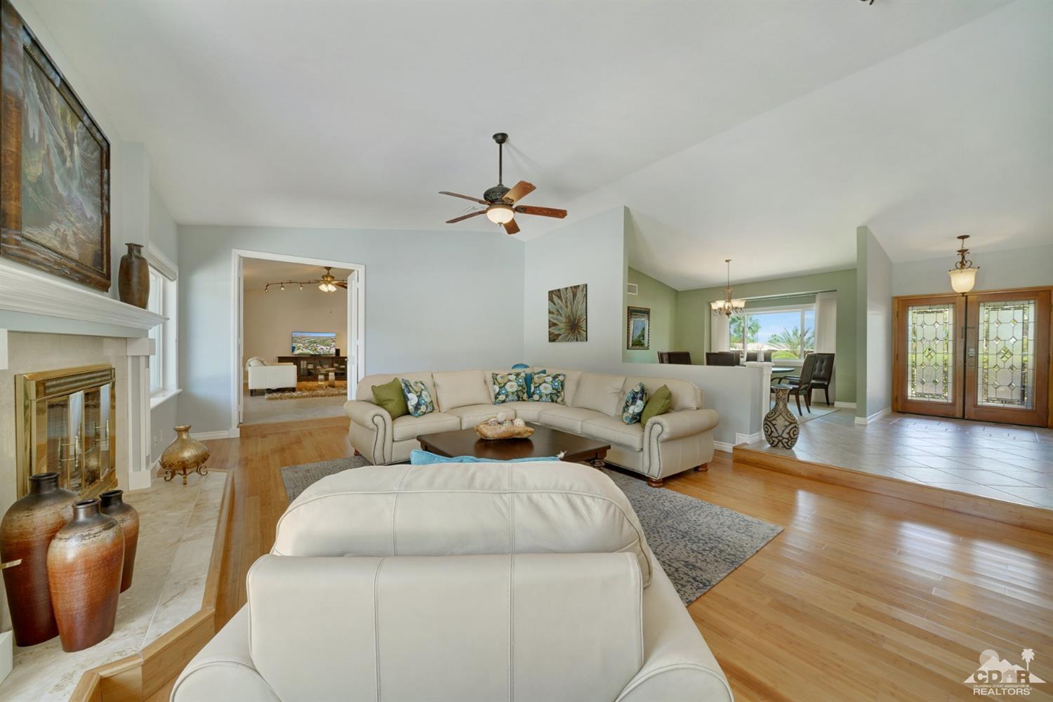 72671 Homestead Road Palm Desert, CA 92260 - Photo 10 of 39 a living room with furniture a fireplace and a chandelier