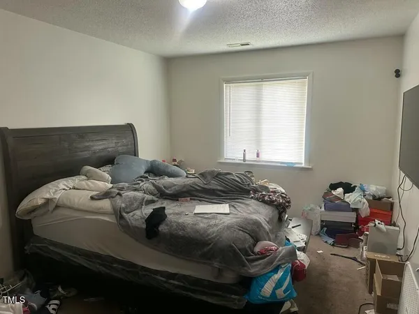 a bed sitting in a bedroom next to a window