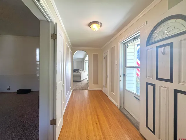 a view of a hallway with wooden floor and staircase