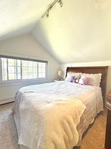 a large bed sitting in a bedroom next to a window
