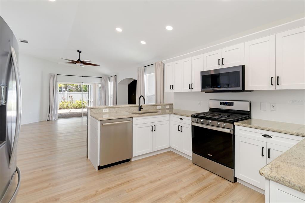 6226 Blueflower Court Lakewood Ranch, FL 34202 - Photo 15 of 81 a kitchen with a stove a sink and a microwave