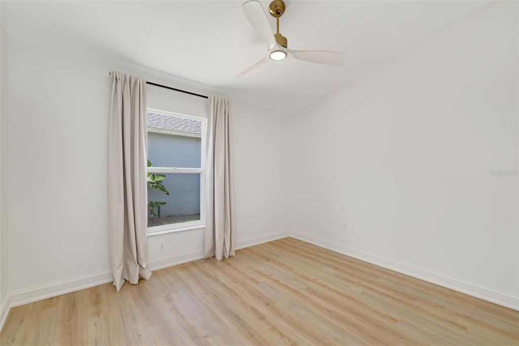 6226 Blueflower Court Lakewood Ranch, FL 34202 - Photo 26 of 81 an empty room with wooden floor mirror and door