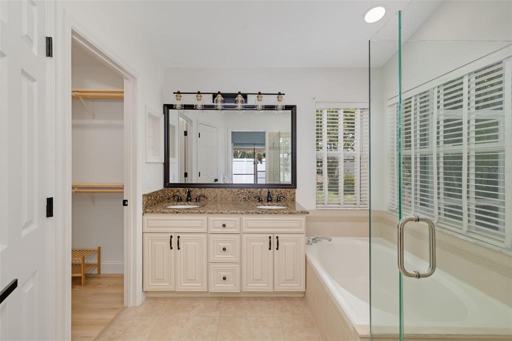6226 Blueflower Court Lakewood Ranch, FL 34202 - Photo 32 of 81 a spacious bathroom with a granite countertop sink mirror and bathtub