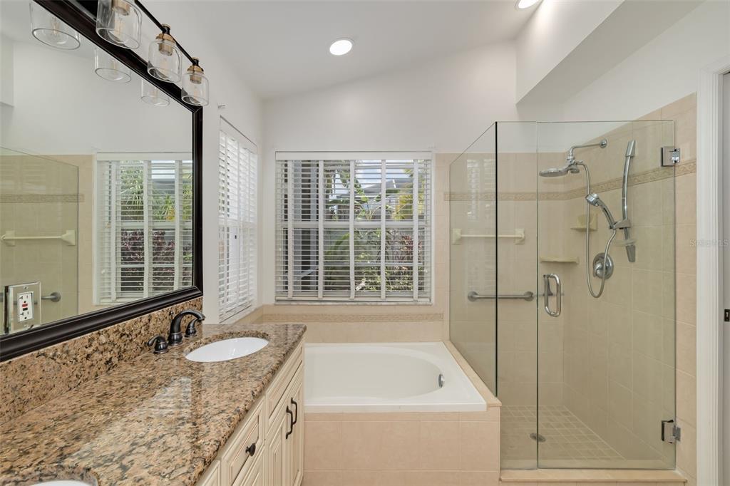 6226 Blueflower Court Lakewood Ranch, FL 34202 - Photo 33 of 81 a bathroom with a granite countertop tub a sink and a shower