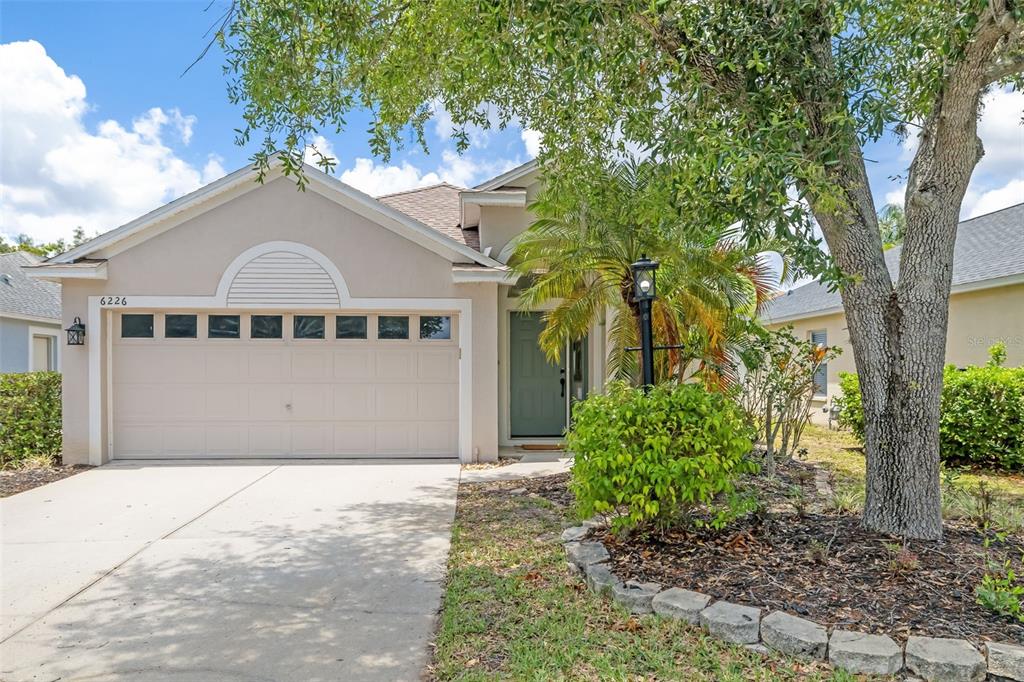 6226 Blueflower Court Lakewood Ranch, FL 34202 - Photo 52 of 81 a view of a house with a yard plants and large tree