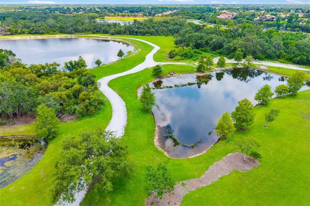 6226 Blueflower Court Lakewood Ranch, FL 34202 - Photo 78 of 81 an aerial view of a house with a yard and lake view