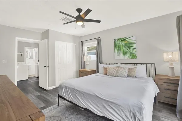 a bedroom with a large bed a painting on the wall and a chandelier