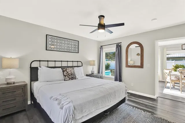 a bedroom with a large bed and wooden floor