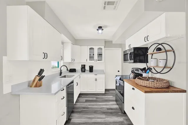 a kitchen with sink a stove and cabinets
