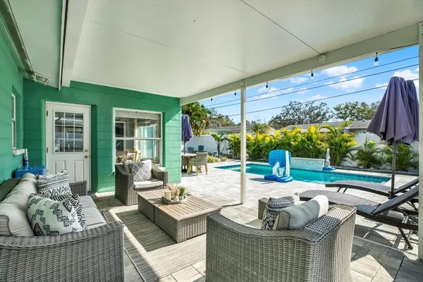a living room with patio furniture and a floor to ceiling window