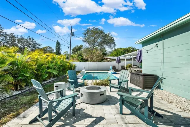 a view of a chairs and table in backyard