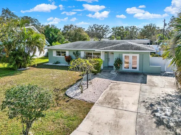 a view of a house with backyard and sitting area
