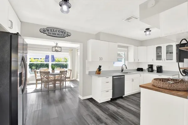 a kitchen with a dining table chairs and white cabinets