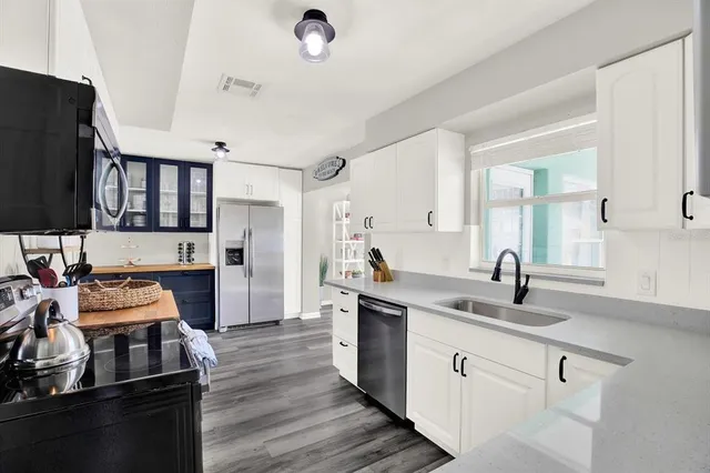 a kitchen with stainless steel appliances granite countertop a sink stove and refrigerator
