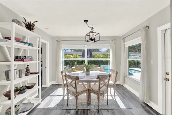a dining room with furniture a chandelier and wooden floor