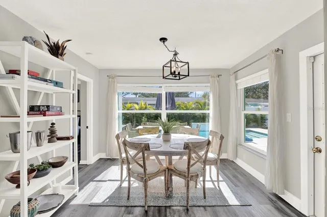 a dining room with furniture a chandelier and wooden floor