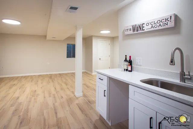 a kitchen with kitchen island a sink wooden floor and glass door