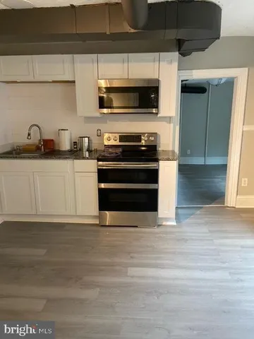 a kitchen with stainless steel appliances a stove and a sink