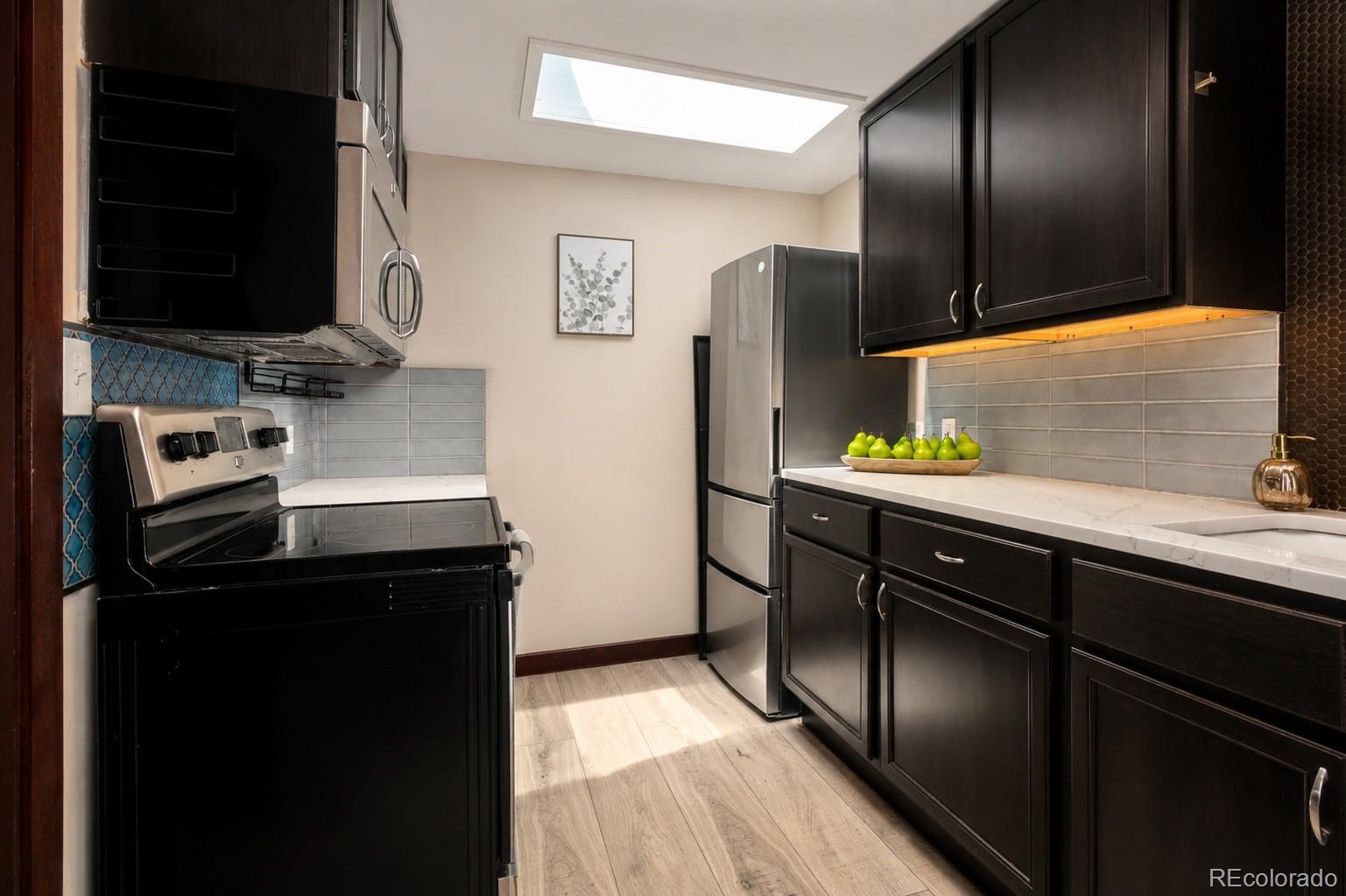 7520 South Blue Creek Road Evergreen, CO 80439 - Photo 5 of 22 a kitchen with stainless steel appliances granite countertop a refrigerator and a sink