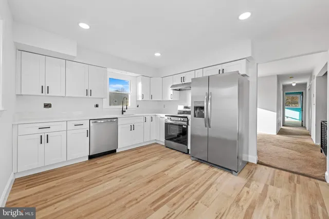 a kitchen with white cabinets and stainless steel appliances