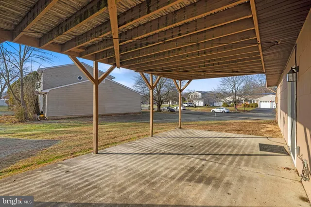 a view of house with backyard and trees in the background