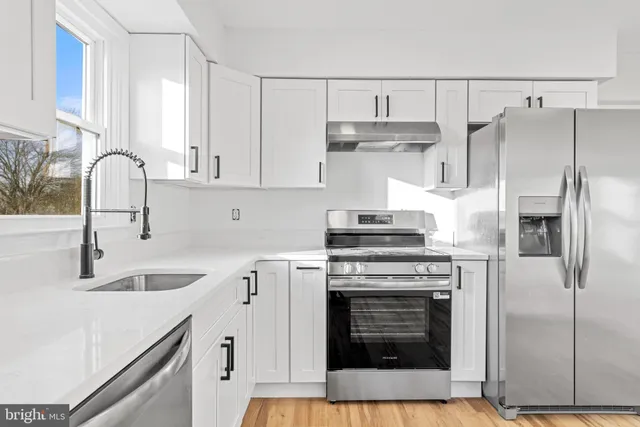 a kitchen with cabinets a sink and stainless steel appliances