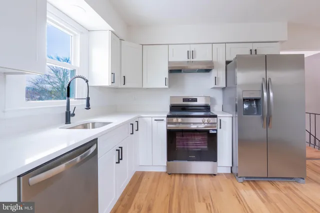 a kitchen with a sink appliances and cabinets