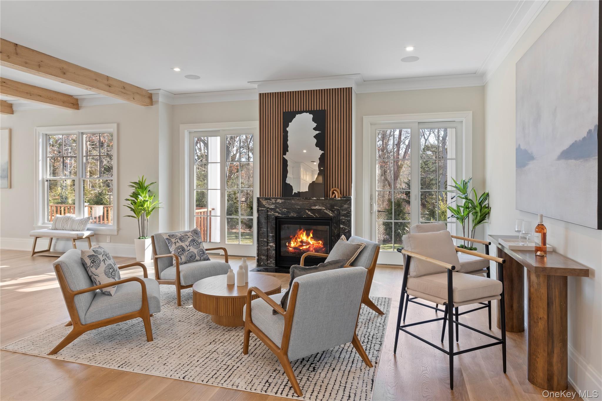 2590 Cox Neck Road Mattituck, NY 11952 - Photo 6 of 50 Anchored by a Heat & Glo propane fireplace, the living space is designed for both relaxed everyday living and elegant entertaining with plenty of natural light