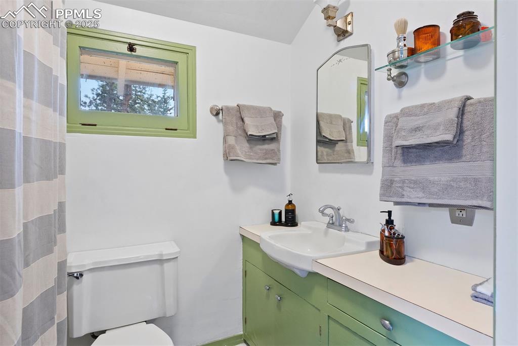 1515 West Cheyenne Road Colorado Springs, CO 80906 - Photo 31 of 50 a bathroom with a toilet a sink and mirror