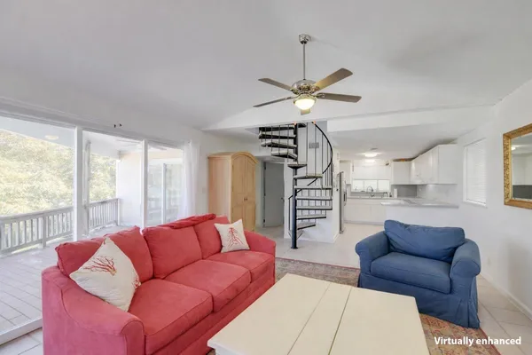a living room with furniture a ceiling fan and a large window