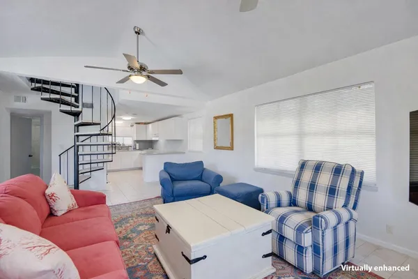 a living room with furniture a ceiling fan and a rug