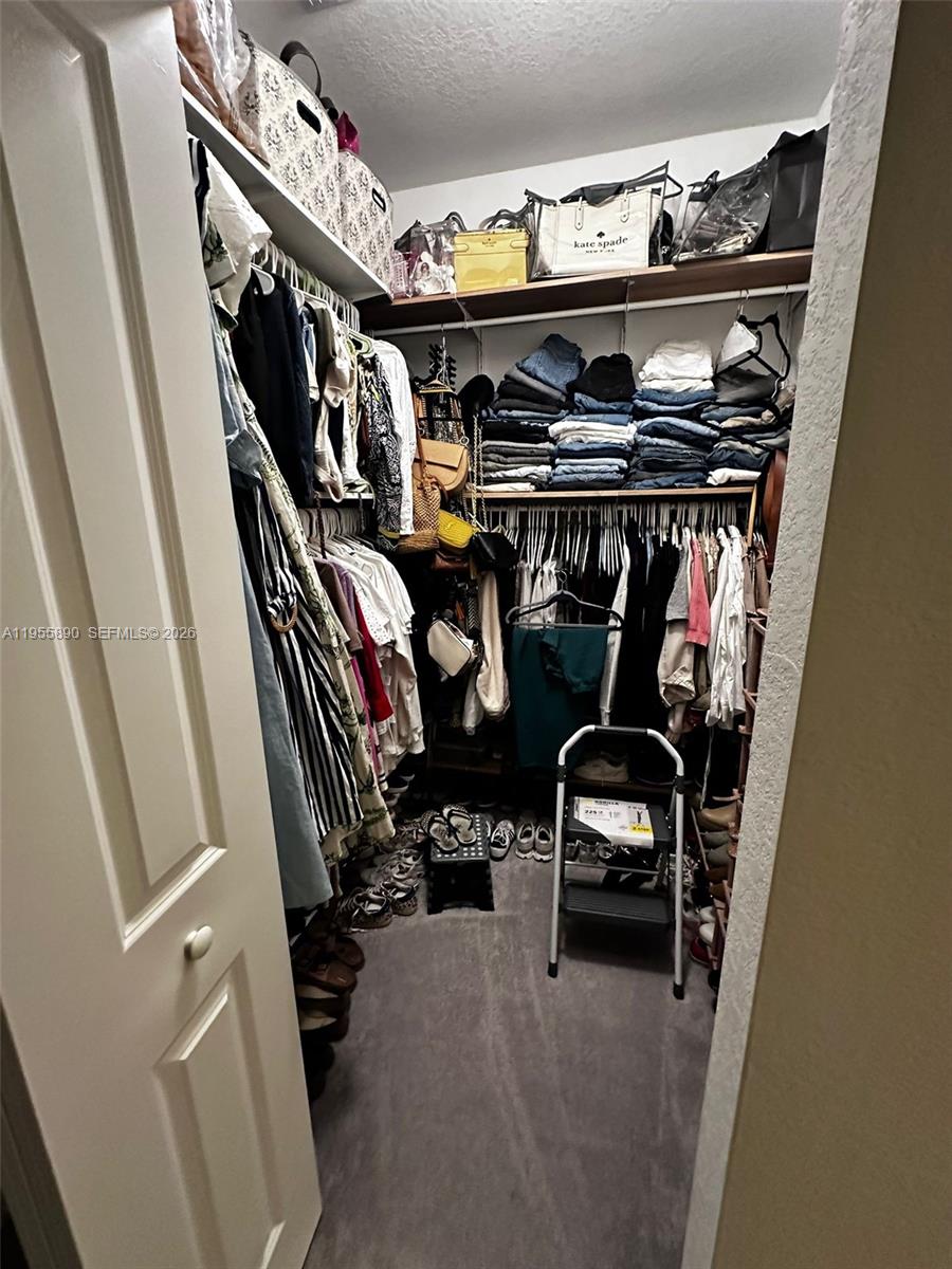 12961 Southwest 230th Street Miami, FL 33170 - Photo 20 of 39 a view of walk in closet with clothes and shoes