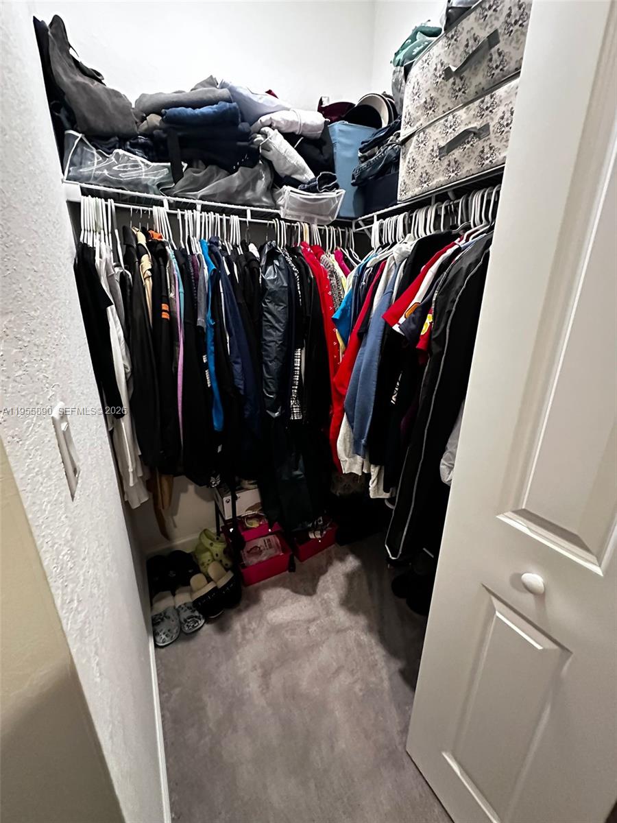 12961 Southwest 230th Street Miami, FL 33170 - Photo 25 of 39 a view of walk in closet with clothes and shoes