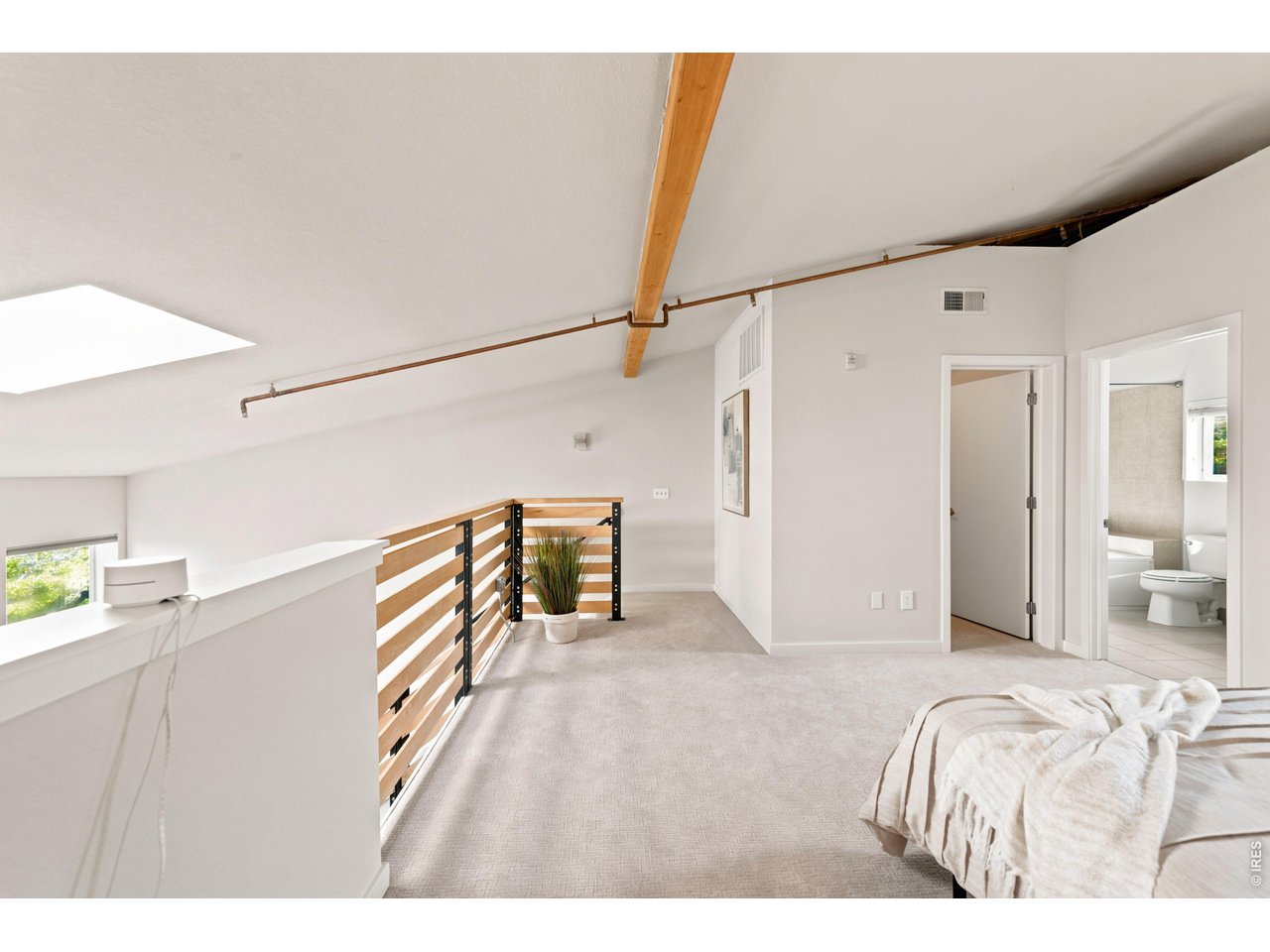 3033 Blake Street, Unit 112 Denver, CO 80205 - Photo 23 of 28 a bedroom with a bed and a chandelier