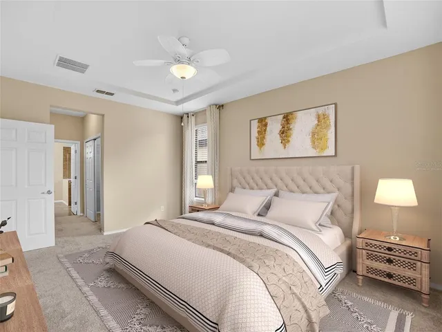 a spacious bedroom with a bed a couch and a flat tv screen on dresser