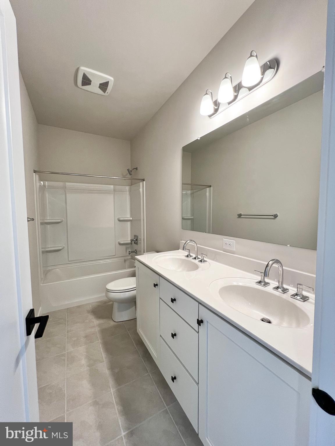 1018 East Lock Road Middletown, DE 19709 - Photo 39 of 51 a bathroom with a double vanity sink a toilet a mirror and shower