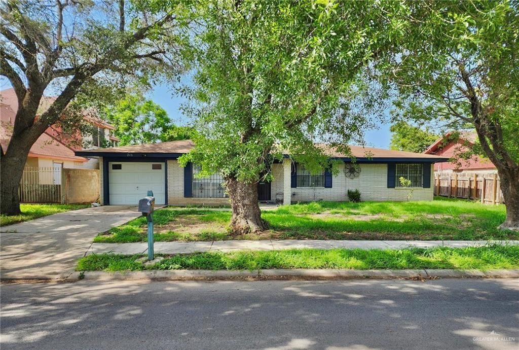 a view of a house with a yard and large trees