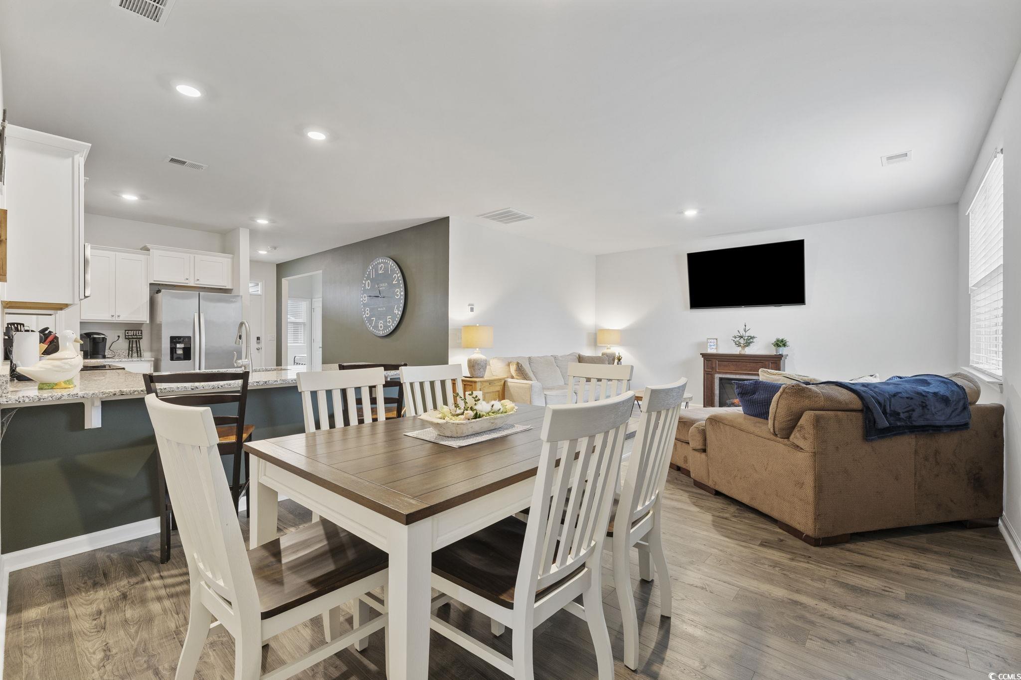 2816 Ophelia Way Myrtle Beach, SC 29577 - Photo 16 of 39 Dining room featuring a glass covered fireplace, recessed lighting, and dark wood finished floors