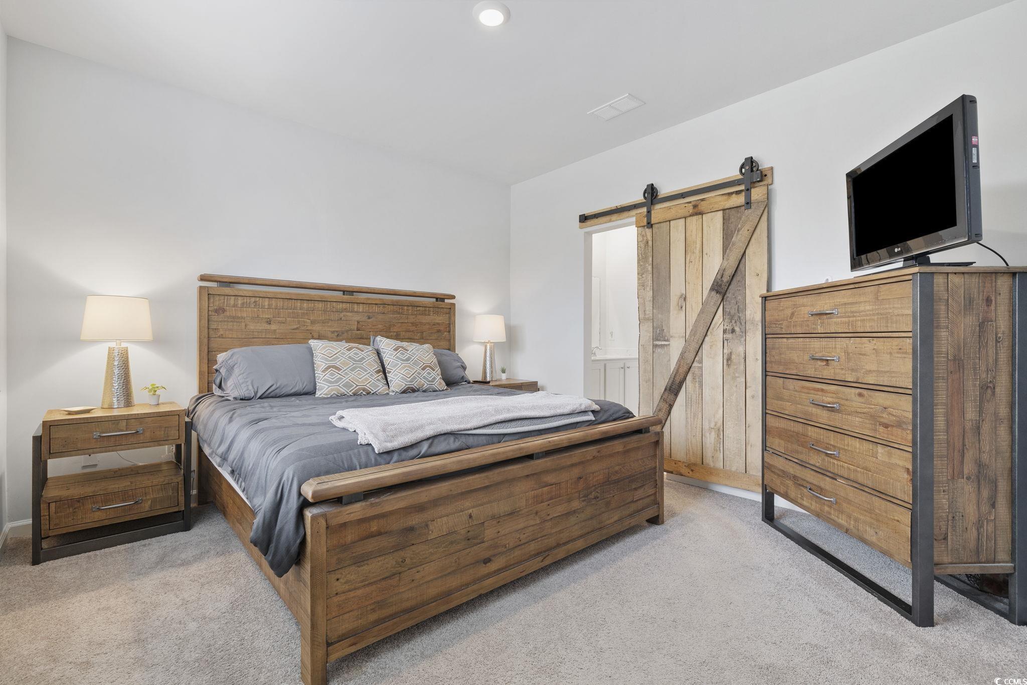 2816 Ophelia Way Myrtle Beach, SC 29577 - Photo 19 of 39 Bedroom with a barn door and light carpet