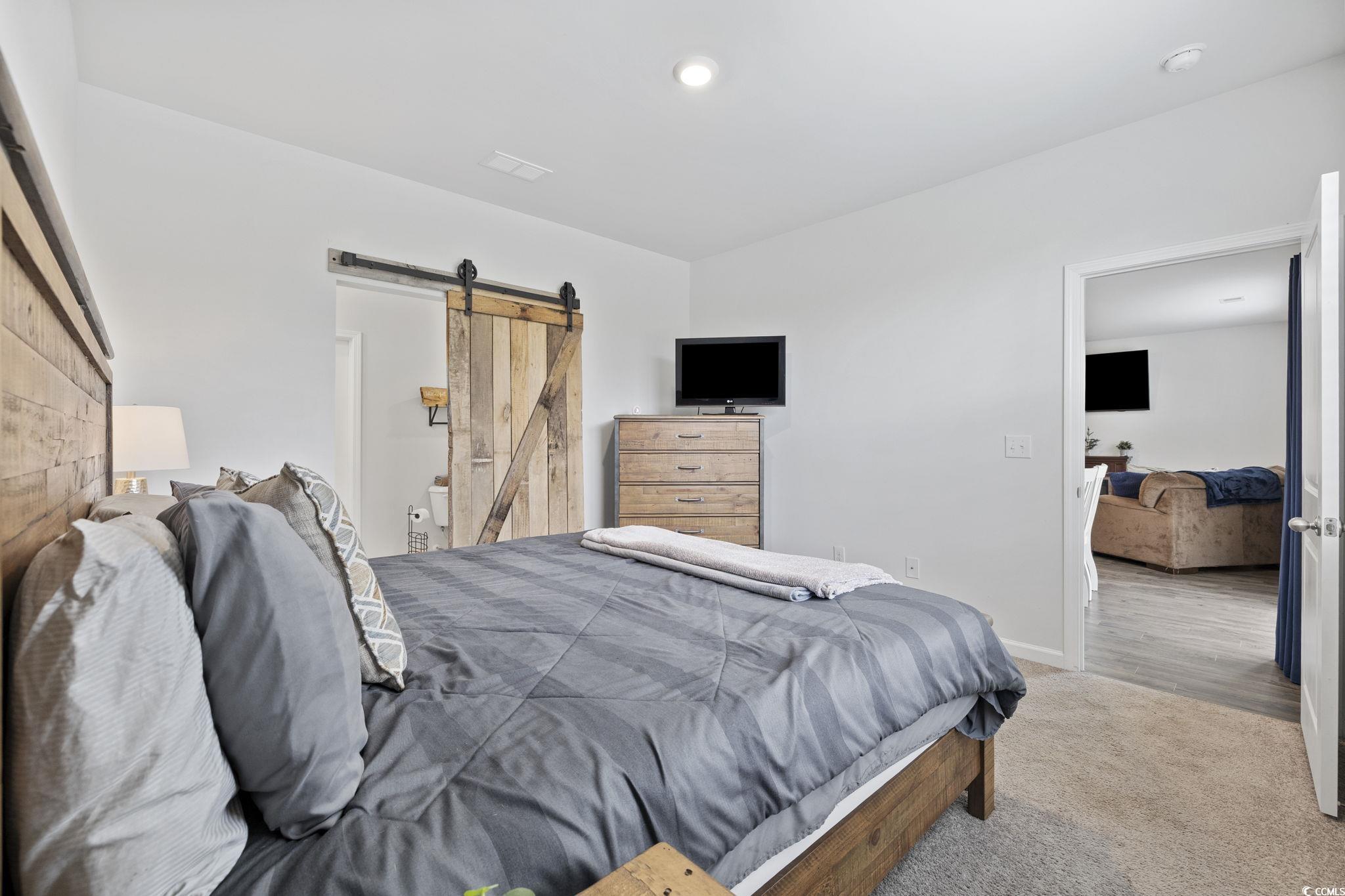 2816 Ophelia Way Myrtle Beach, SC 29577 - Photo 20 of 39 Carpeted bedroom with a barn door and baseboards
