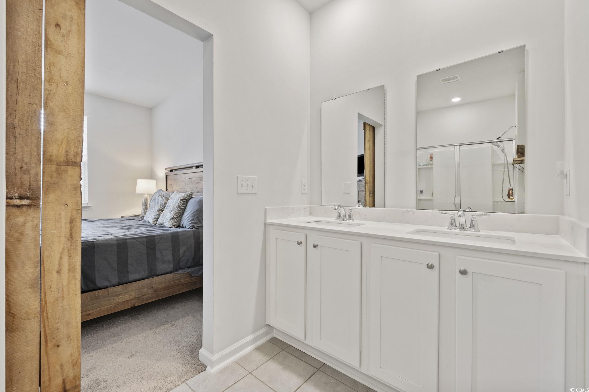 2816 Ophelia Way Myrtle Beach, SC 29577 - Photo 23 of 39 Ensuite bathroom with double vanity, a stall shower, light tile patterned floors, and light carpet